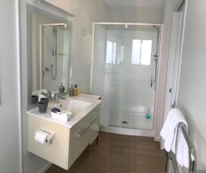 um banheiro branco com chuveiro e pia em Baywaterviews em Paihia