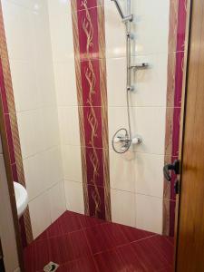 baño con ducha y suelo rojo en Апартамент за гости Байрактарова, en Smolyan