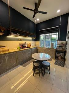 a kitchen with a table and a ceiling fan at Cozy Beach Getaway in Kampong Baharu Cherating