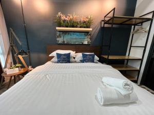 1 dormitorio con 1 cama grande y toallas. en Cozy Beach Getaway, en Kampong Baharu Cherating