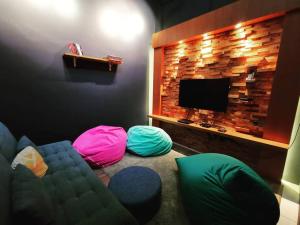 a living room with a couch and a tv at Cozy Beach Getaway in Kampong Baharu Cherating