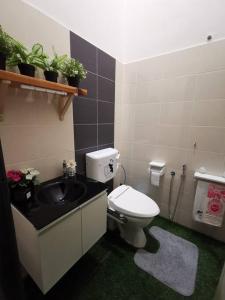 a bathroom with a toilet and a sink at Cozy Beach Getaway in Kampong Baharu Cherating
