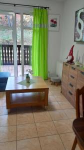 a living room with a table and a green curtain at Apartament 4 osobowy, sauna, sala fitness in Szklarska Poręba