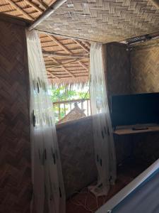 a room with a window with curtains on it at Bice Camp Darocotan in El Nido