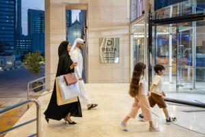 um grupo de pessoas andando em frente a um edifício em Delta Hotels by Marriott City Center Doha em Doha