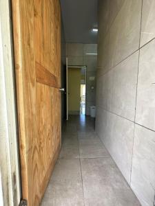 um corredor com uma porta de madeira num quarto em PUNAEI LODGE em Atuona