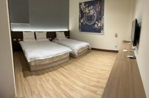 a room with two beds and a flat screen tv at 五星佶民宿 in Jinning