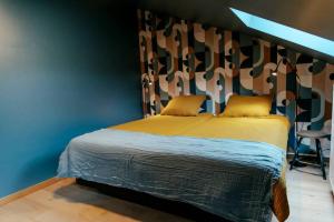 a bedroom with a bed and a blue wall at Le rétro chic - Grand Duplex pour 6 dans le centre in Liège