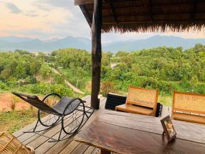 a porch with chairs and a table with a view at Utopua Resort ยูโทปัวว์ รีสอร์ท in Pua