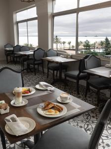 a dining room with tables and chairs with breakfast foods at Parade Hotel in Durban