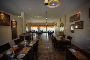 a restaurant with wooden tables and chairs and a dining room at Sawasstika Eco Park Resort in Binnāguri