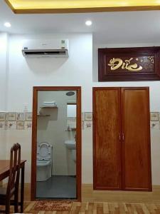 a bathroom with a toilet and a wooden door at Sơn Tùng Motel in Ấp Trà Kha