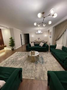 a living room with green couches and a table at شقة فندقيه معقمه للإجار اليومي او الشهري in Cairo