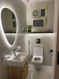 a bathroom with a sink and a toilet and a mirror at شقة فندقيه معقمه للإجار اليومي او الشهري in Cairo