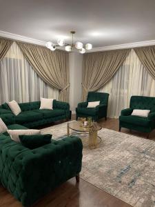 a living room with green couches and a table at شقة فندقيه معقمه للإجار اليومي او الشهري in Cairo