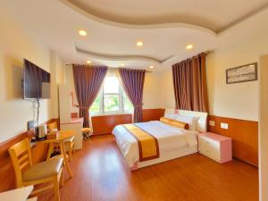 a hotel room with a bed and a desk at Villa H Flower Đà Lạt in Da Lat