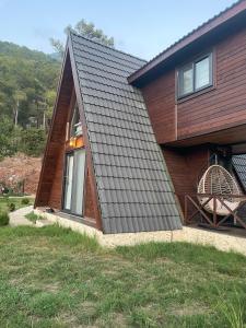 a house with a metal roof and a large window at Doğanın İçinde Lüks Jakuzili Balayı Bungalovu(роскошное шале с джакузи) in Kumluca