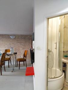 ein Bad mit einer Dusche und einem Tisch mit Stühlen in der Unterkunft Apartments "Belle Vue" in Herceg-Novi