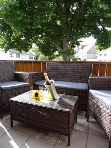 un patio con una mesa y una botella de champán en Ferienhaus van Vliet, en Morbach