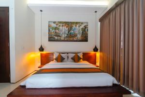 a bedroom with a large bed and a painting on the wall at Villa C31 Seminyak in Seminyak