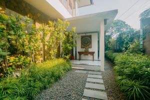 a garden with a pathway leading to a house at Villa C31 Seminyak in Seminyak