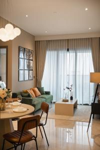 a living room with a green couch and a table at MarQ Luxury Apartment by NEST Group in Ho Chi Minh City