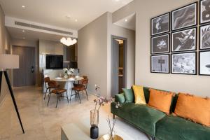 a living room with a green couch and a table at MarQ Luxury Apartment by NEST Group in Ho Chi Minh City