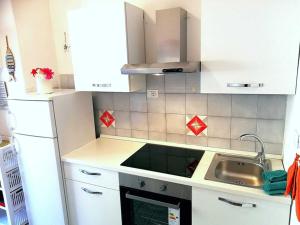 a kitchen with white cabinets and a sink at Ginestra in Campese