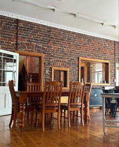 une salle à manger avec un mur en briques, une table et des chaises dans l'établissement THE FED AND BED TEMORA, à Temora