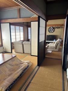 a bedroom with a bed and a living room at 福寿苑　Fukujuen in Oshino