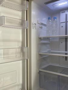 - un réfrigérateur ouvert avec 2 bouteilles d'eau dans l'établissement Thine Room, à Suwon