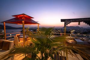 a balcony with a view of the city at sunset at The Lake View Hotel- On Lake Pichola in Udaipur