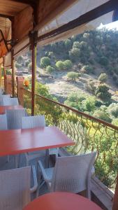 een balkon met tafels en stoelen en uitzicht op een heuvel bij Gite Rahhaoui Simo in Kasba des Aït Moussa
