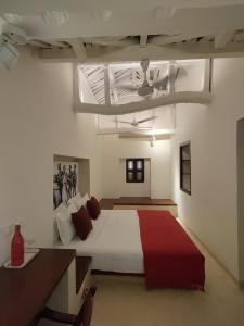 ein Schlafzimmer mit einem großen weißen Bett mit roten Kissen in der Unterkunft Mangala Heritage by LuxUnlock Private Villas in Tirukkannapuram