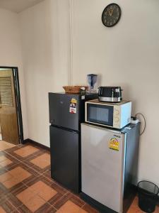 a kitchen with two refrigerators and a microwave on a refrigerator at Гостевой дом in Bophut