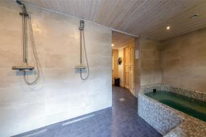 ein Badezimmer mit einer grünen Badewanne und einer Dusche in der Unterkunft Veldemani puhkemaja in Vaibla