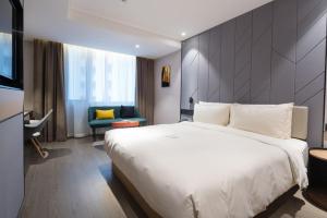 a hotel room with a large bed and a chair at Atour S Hotel Guangzhou Tianhe Taikoo Hui in Guangzhou