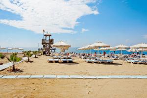 una spiaggia con sedie e ombrelloni e l'oceano di TUI BLUE Pascha Bay a Konaklı