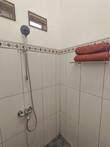 a bathroom with a shower with a red towel at Pondok Selip Guesthouse in Krambitan
