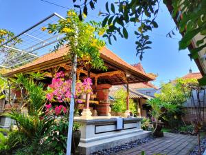 a house with a garden with flowers in front of it at Pondok Selip Guesthouse in Krambitan
