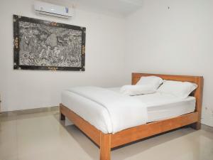 a bed with two white pillows on it in a room at Pondok Selip Guesthouse in Krambitan