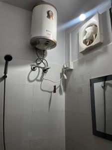 a bathroom with a light on the wall at EJ’s Frontyard- The Home Cafe & Stay in Kurseong