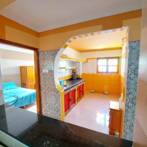 een keuken met een wastafel en een kamer met een bed bij Gite Rahhaoui Simo in Kasba des Aït Moussa