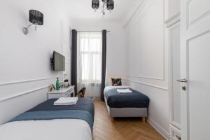 - une chambre avec 2 lits, un bureau et une fenêtre dans l'établissement Rent like home - Lwowska 9, à Varsovie