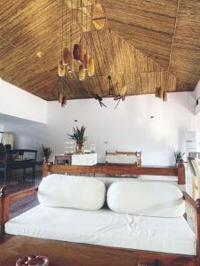 Cette chambre comprend 2 lits blancs dans un plafond en bois. dans l'établissement Machan Country Villa, à Chitwan