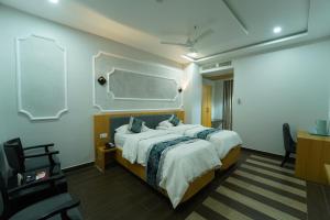 a bedroom with a large bed and a desk at Dvr Mansion in Kurnool