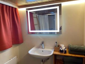 La salle de bains est pourvue d'un lavabo et d'un miroir. dans l'établissement Alpenchalet Haldeli Gstaad Ferienwohnung im 1-Stock, à Gstaad