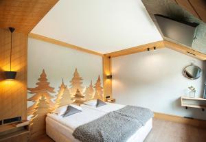ein Schlafzimmer mit einem Bett und einer Wand mit Weihnachtsbäumen in der Unterkunft "Park Hotel Ela" in Borowez