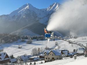 einen Skilift mit Schneespekulation auf einer Skipiste in der Unterkunft Privát Bachleda Ždiar in Ždiar