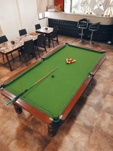 a green pool table in a room with tables and chairs at Sawasstika Eco Park Resort in Binnāguri